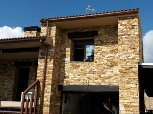 Fachada rústica de piedra natural en vivienda unifamiliar.